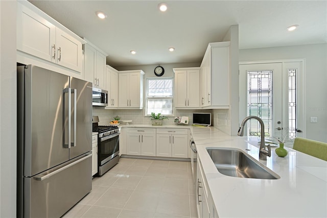 kitchen with tasteful backsplash, white cabinetry, recessed lighting, appliances with stainless steel finishes, and a sink
