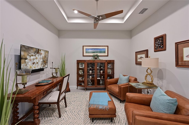office featuring visible vents, baseboards, a ceiling fan, and a tray ceiling
