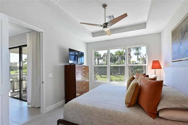 bedroom featuring baseboards, a textured ceiling, visible vents, access to exterior, and a tray ceiling