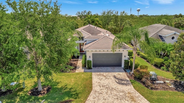 5009 Lake Overlook Ave, Bradenton, FL 34208 - view of front of property featuring a front yard, a garage, a tile roof, stucco siding, and decorative driveway