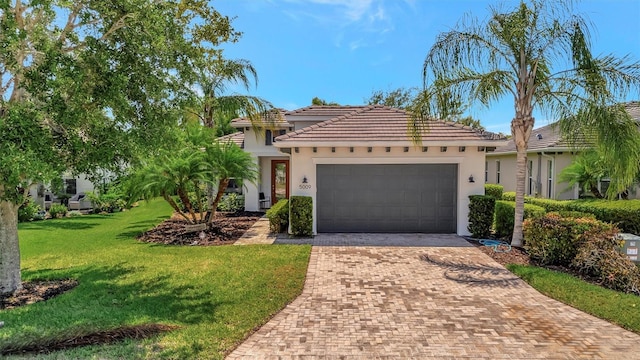 5009 Lake Overlook Ave, Bradenton, FL 34208 - mediterranean / spanish-style house with a front yard, a tiled roof, a garage, stucco siding, and decorative driveway