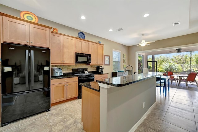5009 Lake Overlook Ave, Bradenton, FL 34208 - kitchen featuring tasteful backsplash, visible vents, a kitchen island with sink, black appliances, and dark stone counters