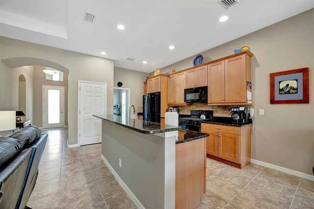 5009 Lake Overlook Ave, Bradenton, FL 34208 - kitchen with visible vents, black appliances, arched walkways, and a center island with sink