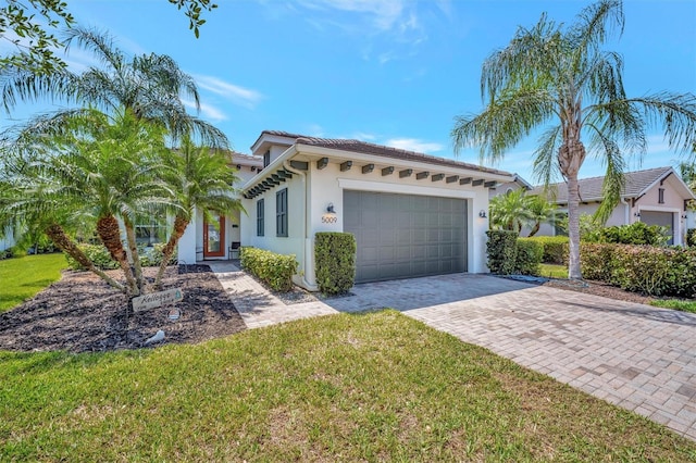 5009 Lake Overlook Ave, Bradenton, FL 34208 - view of front of home with stucco siding, decorative driveway, a front lawn, a tile roof, and a garage