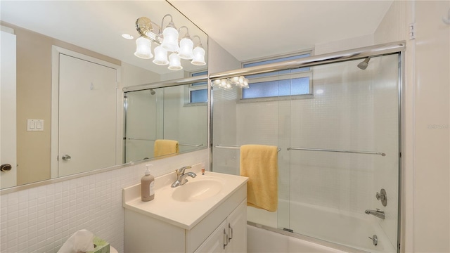 4350 Chatham Dr Unit E-105, Longboat Key, FL 34228 - bathroom with bath / shower combo with glass door, vanity, and tile walls