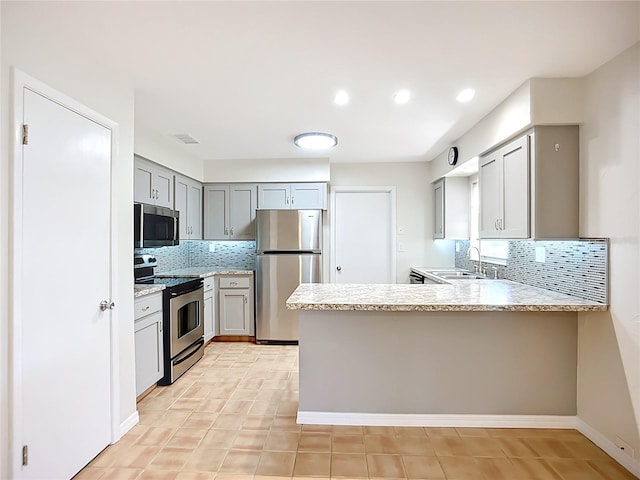 2705 21st Ave W, Bradenton, FL 34205 - kitchen featuring a peninsula, a sink, backsplash, gray cabinets, and appliances with stainless steel finishes