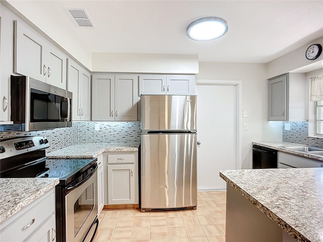2705 21st Ave W, Bradenton, FL 34205 - kitchen featuring stainless steel appliances, visible vents, light tile patterned floors, a sink, and decorative backsplash