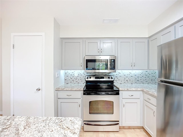 2705 21st Ave W, Bradenton, FL 34205 - kitchen with light stone countertops, decorative backsplash, visible vents, and appliances with stainless steel finishes
