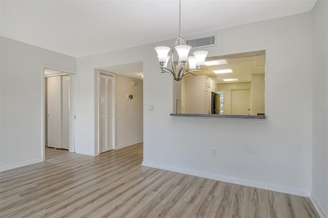 7173 W Country Club Dr N Unit 141, Sarasota, FL 34243 - unfurnished dining area with a chandelier, light wood-style floors, visible vents, and baseboards