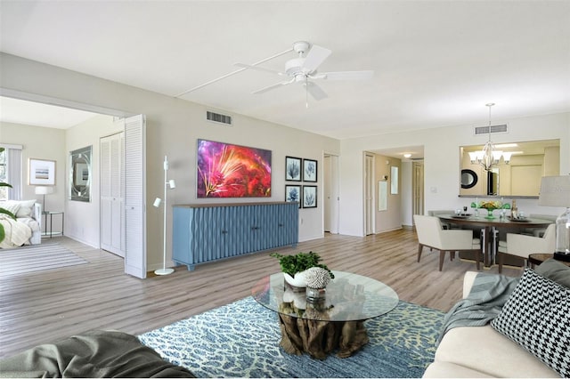 7173 W Country Club Dr N Unit 141, Sarasota, FL 34243 - living room featuring wood finished floors, ceiling fan with notable chandelier, and visible vents