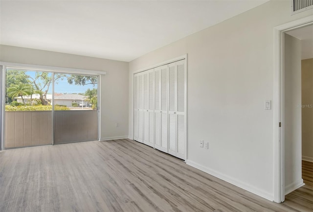 7173 W Country Club Dr N Unit 141, Sarasota, FL 34243 - unfurnished bedroom featuring visible vents, baseboards, a closet, and wood finished floors