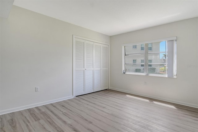 7173 W Country Club Dr N Unit 141, Sarasota, FL 34243 - unfurnished bedroom with wood finished floors, a closet, and baseboards