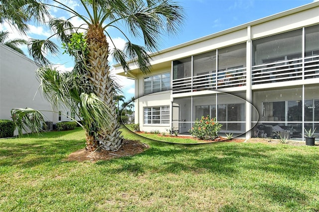 7173 W Country Club Dr N Unit 141, Sarasota, FL 34243 - back of house with stucco siding, a sunroom, and a lawn