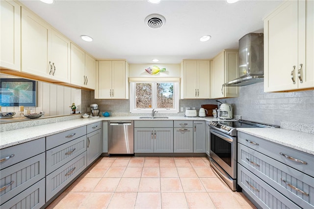8592 Hidden Lagoon Rd, Sarasota, FL 34242 - kitchen featuring appliances with stainless steel finishes, wall chimney range hood, gray cabinets, backsplash, and recessed lighting
