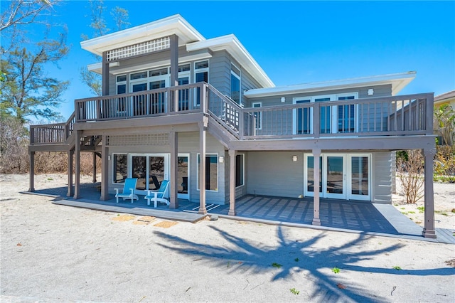 8592 Hidden Lagoon Rd, Sarasota, FL 34242 - rear view of house featuring a patio area, a wooden deck, and a balcony