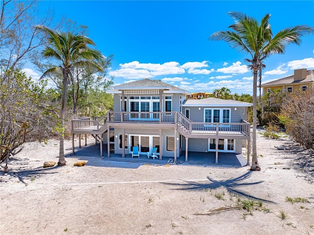 8592 Hidden Lagoon Rd, Sarasota, FL 34242 - rear view of house featuring a wooden deck, stairs, a patio area, driveway, and a carport