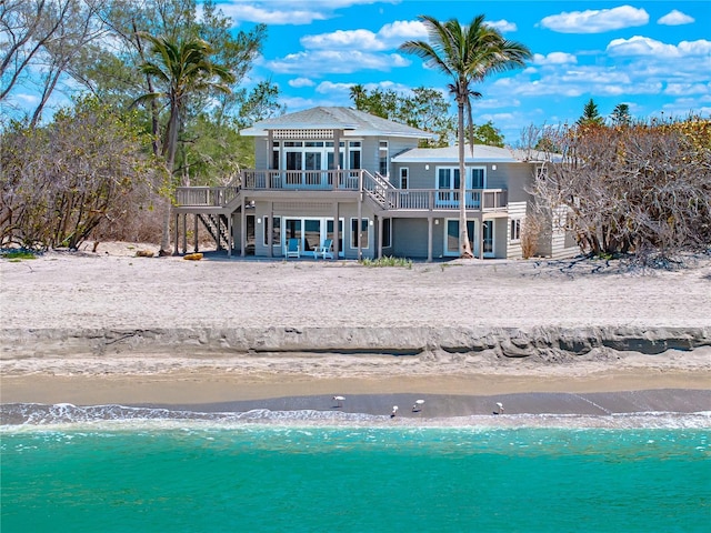 8592 Hidden Lagoon Rd, Sarasota, FL 34242 - back of property with a beach view, stairway, and a deck with water view
