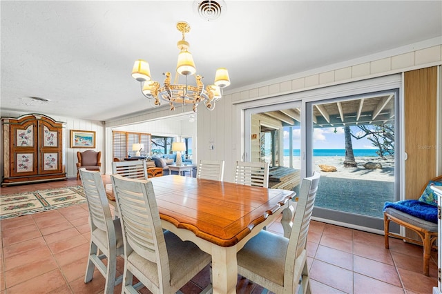 8592 Hidden Lagoon Rd, Sarasota, FL 34242 - dining area featuring a chandelier, light tile patterned floors, and a water view