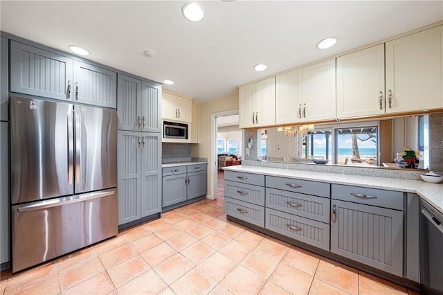 8592 Hidden Lagoon Rd, Sarasota, FL 34242 - kitchen with stainless steel appliances, gray cabinets, light countertops, light tile patterned floors, and recessed lighting