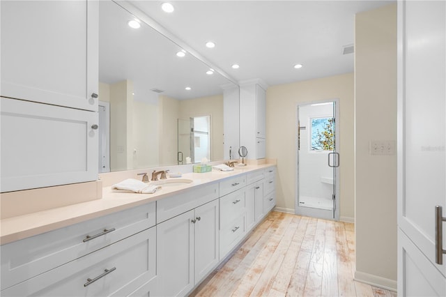 8592 Hidden Lagoon Rd, Sarasota, FL 34242 - full bathroom with double vanity, a shower stall, recessed lighting, and wood finished floors