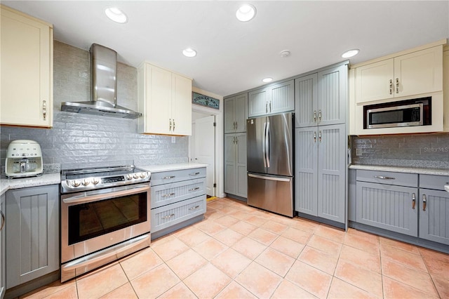 8592 Hidden Lagoon Rd, Sarasota, FL 34242 - kitchen with stainless steel appliances, wall chimney exhaust hood, gray cabinets, backsplash, and light tile patterned floors