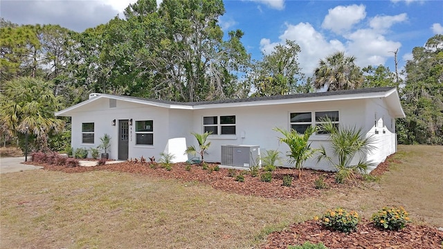 ranch-style house with central AC unit, stucco siding, and a front lawn