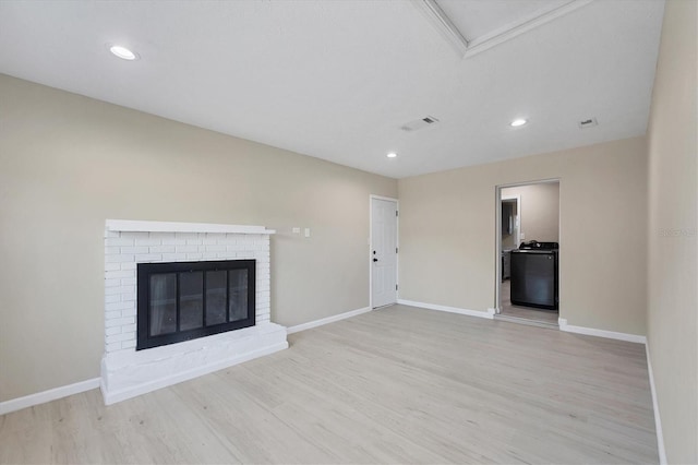 unfurnished living room featuring recessed lighting, baseboards, washer / dryer, wood finished floors, and visible vents