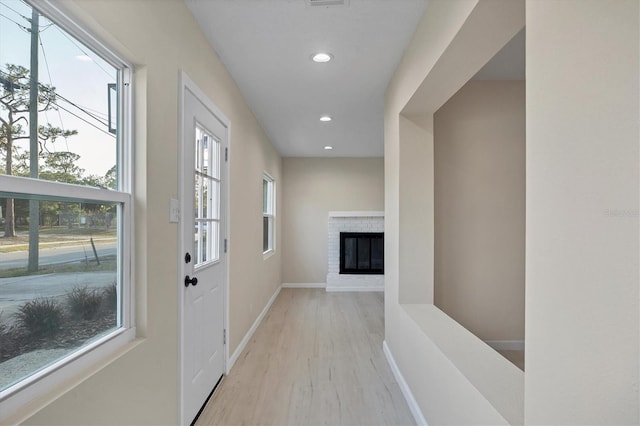 hall featuring light wood-style floors, baseboards, and recessed lighting