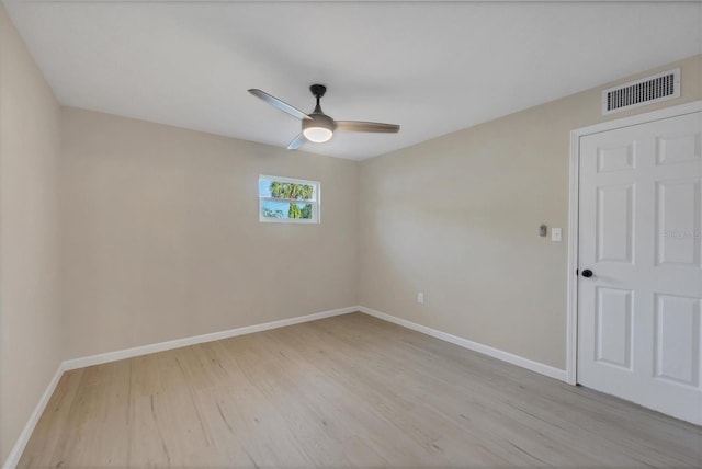 spare room with baseboards, visible vents, ceiling fan, and light wood finished floors