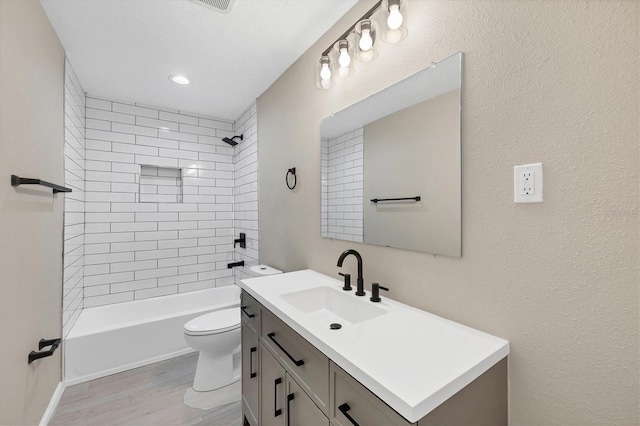 bathroom with vanity, toilet, wood finished floors, and tub / shower combination