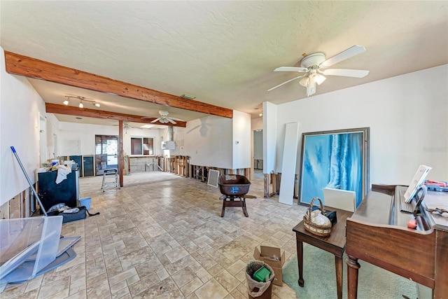 living room with beam ceiling and a ceiling fan