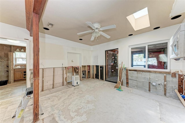 spare room with a skylight, a healthy amount of sunlight, ceiling fan, and visible vents
