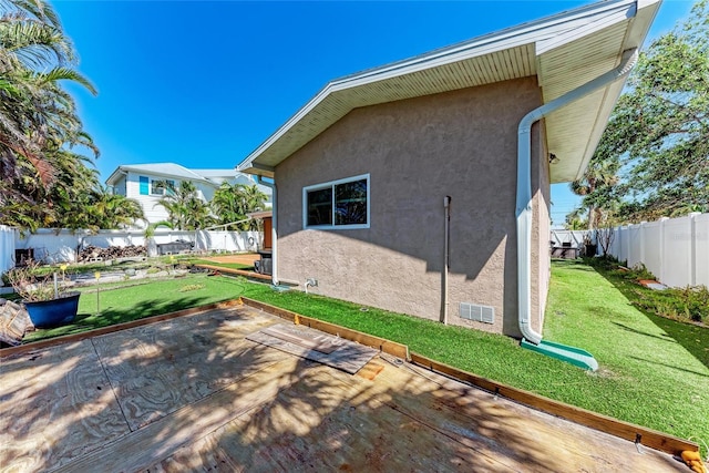 view of side of home featuring a yard, a fenced backyard, a patio, and stucco siding