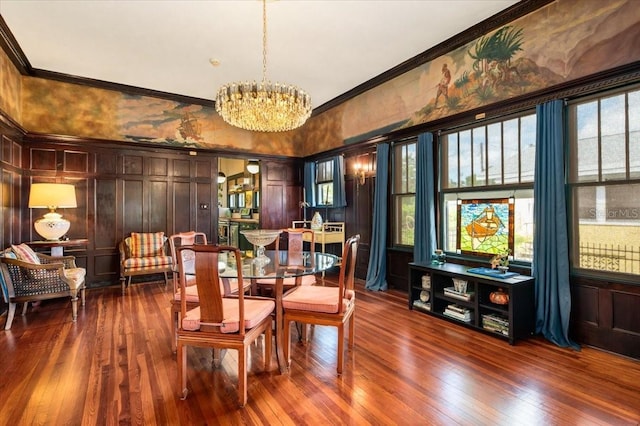 2326 2nd Ave E, Bradenton, FL 34208 - dining space with crown molding, a chandelier, dark wood-type flooring, and a decorative wall