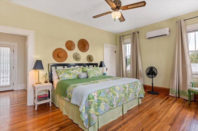 2326 2nd Ave E, Bradenton, FL 34208 - bedroom featuring a wall mounted AC, wood finished floors, baseboards, and ceiling fan