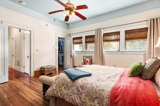 2326 2nd Ave E, Bradenton, FL 34208 - bedroom featuring wood finished floors, a walk in closet, a closet, baseboards, and a ceiling fan