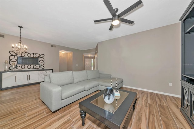 1712 Starling Dr Unit 101, Sarasota, FL 34231 - living area featuring light wood-type flooring, baseboards, ceiling fan with notable chandelier, and visible vents