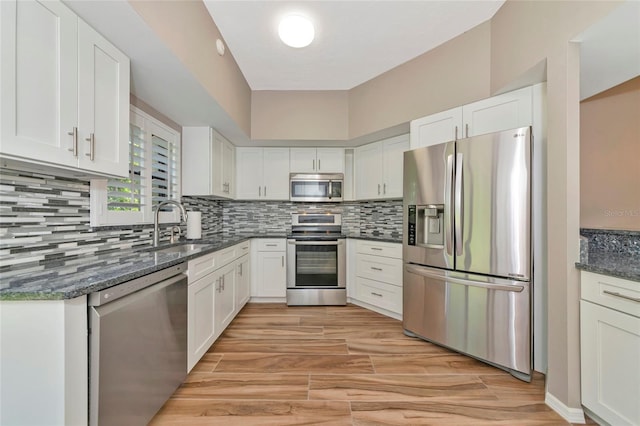 1712 Starling Dr Unit 101, Sarasota, FL 34231 - kitchen featuring a sink, tasteful backsplash, stainless steel appliances, and white cabinetry