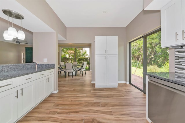 1712 Starling Dr Unit 101, Sarasota, FL 34231 - kitchen with decorative light fixtures, stainless steel dishwasher, light wood finished floors, dark stone counters, and white cabinetry