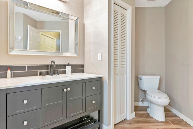 1712 Starling Dr Unit 101, Sarasota, FL 34231 - bathroom with vanity, toilet, baseboards, wood finished floors, and a closet