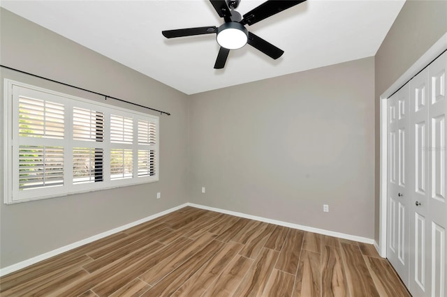 1712 Starling Dr Unit 101, Sarasota, FL 34231 - unfurnished bedroom with baseboards, ceiling fan, light wood-style flooring, and a closet