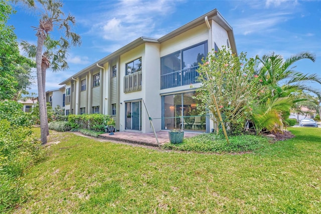 1712 Starling Dr Unit 101, Sarasota, FL 34231 - back of house with a patio area, stucco siding, and a yard