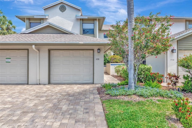 1712 Starling Dr Unit 101, Sarasota, FL 34231 - traditional-style house with roof with shingles, stucco siding, and driveway