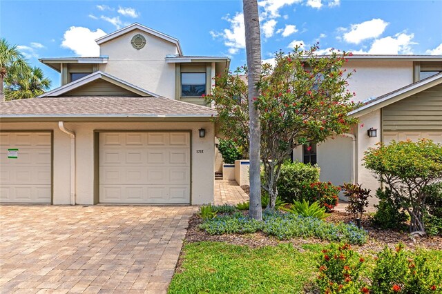 1712 Starling Dr Unit 101, Sarasota, FL 34231 - traditional-style house with a garage, stucco siding, driveway, and a shingled roof