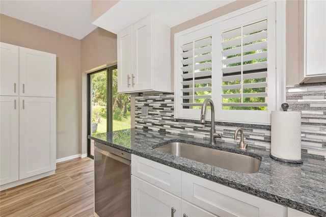 1712 Starling Dr Unit 101, Sarasota, FL 34231 - kitchen featuring a sink, decorative backsplash, dishwasher, and white cabinets