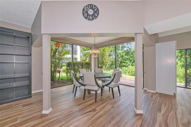 1712 Starling Dr Unit 101, Sarasota, FL 34231 - dining space with an inviting chandelier, baseboards, and light wood-type flooring