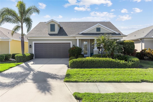 6936 White Willow Ct, Sarasota, FL 34243 - view of front of house with concrete driveway, stucco siding, an attached garage, a front yard, and a shingled roof