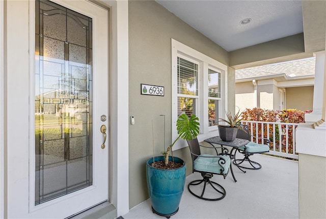6936 White Willow Ct, Sarasota, FL 34243 - view of exterior entry featuring a porch and stucco siding