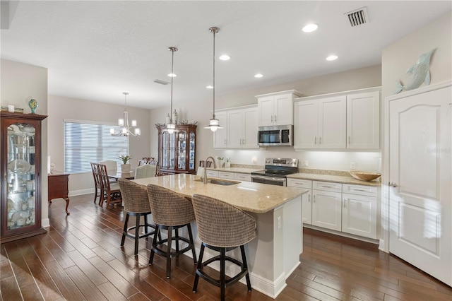 6936 White Willow Ct, Sarasota, FL 34243 - kitchen featuring recessed lighting, a sink, stainless steel appliances, a breakfast bar area, and dark wood-style floors