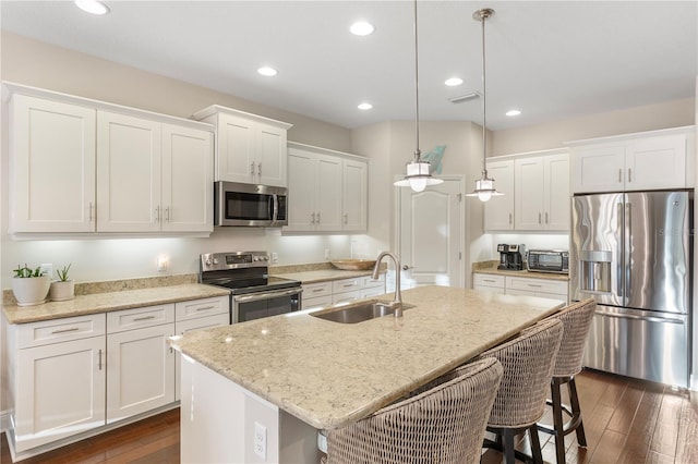 6936 White Willow Ct, Sarasota, FL 34243 - kitchen with stainless steel appliances, white cabinetry, a sink, and dark wood finished floors